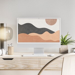 Puede incluir: Una moderna configuraci&oacute;n de oficina en casa con un monitor de computadora blanco que muestra una impresi&oacute;n art&iacute;stica de paisaje abstracto. El escritorio es de madera clara e incluye una l&aacute;mpara, auriculares y una planta en maceta. Una silla de madera est&aacute; en primer plano.