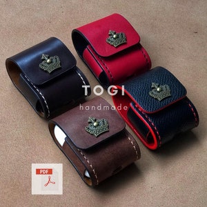 Può includere: Quattro custodie in pelle per auricolari wireless, ognuna con un colore diverso e un design a corona dorata. Le custodie sono disposte a semicerchio su una superficie marrone. Il testo "TOGI handmade" è visibile al centro dell'immagine.