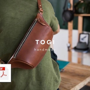 May include: A brown leather fanny pack with a zipper closure and a strap. The bag is worn by a person and has the text "TOGI handmade" on the front.