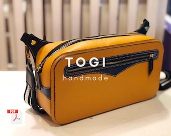 May include: A yellow leather crossbody bag with black trim and a zipper closure. The bag has a black and white striped strap and the text "TOGI handmade" on the front.