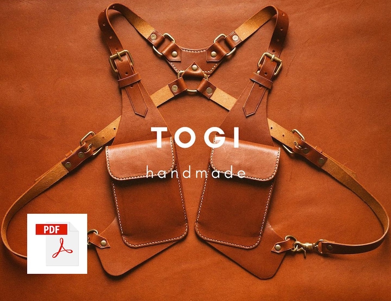 May include: A brown leather chest rig with two pockets and adjustable straps. The rig has brass hardware and the text "TOGI handmade" printed on the front.