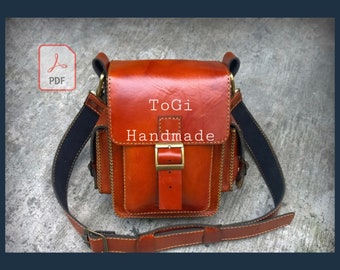 Könnte beinhalten: Eine braune Lederschultertasche mit Klappenverschluss und Schnalle. Die Tasche hat ein Reißverschlussfach vorne und ein kleineres Fach an der Seite. Die Tasche ist mit "ToGi Handmade" beschriftet.