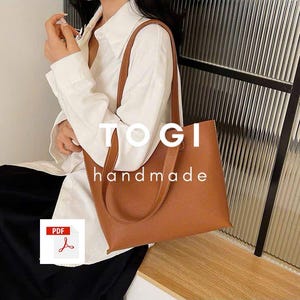 May include: A brown leather tote bag with the text "TOGI handmade" printed on the front.