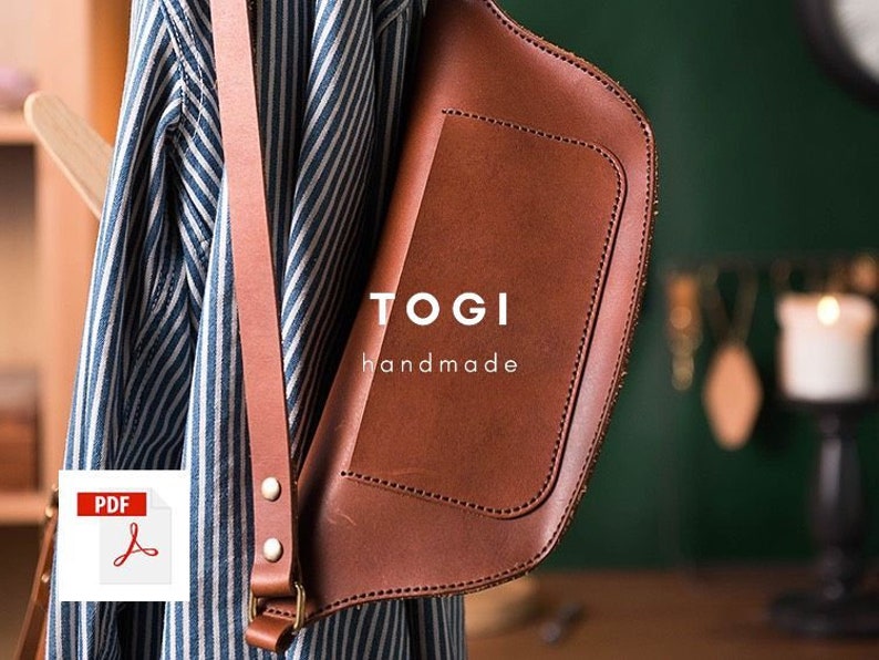 May include: A brown leather crossbody bag with a flap closure and a strap. The bag has the text "TOGI handmade" on the front.