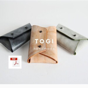 Puede incluir: Tres porta tarjetas de cuero en gris, beige y verde claro. El porta tarjetas beige tiene el texto "TOGI handmade" en la parte delantera.
