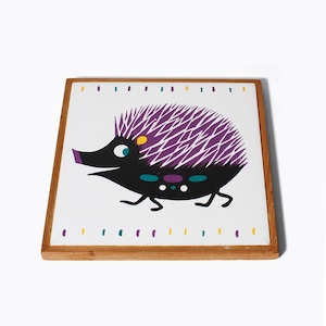 May include: A wooden framed tile featuring a colourful illustration of a purple and black hedgehog with yellow and teal accents.