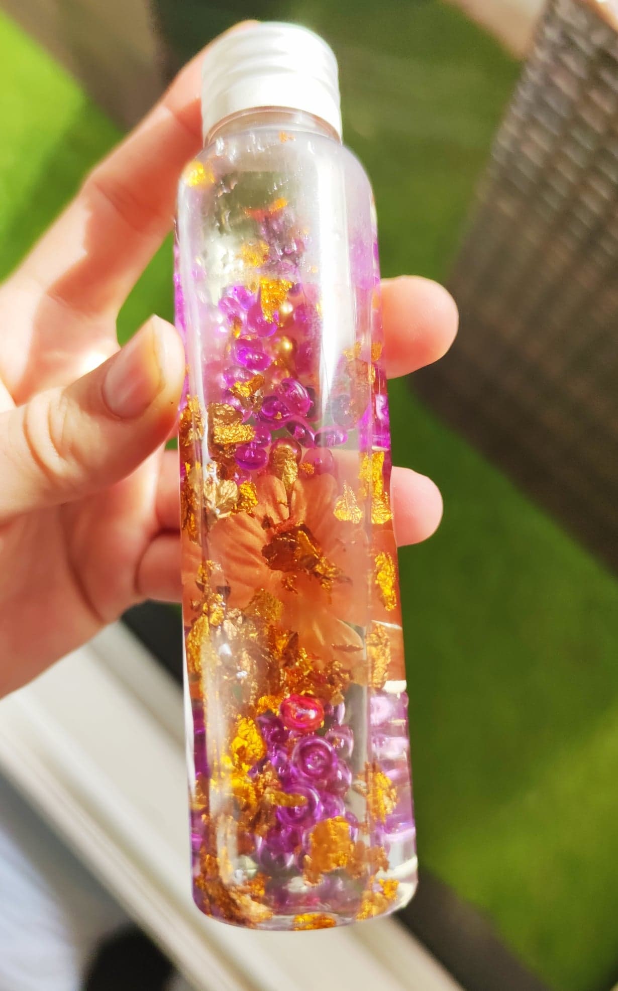 bouteille sensorielle eau, glycérine végétale (effet lent) feuille d'or,  fleur et perles. Bouteille sécurisée, méthode montessori