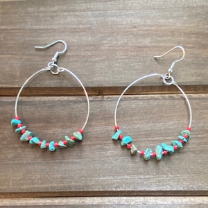 May include: A pair of silver hoop earrings with turquoise and red beads.