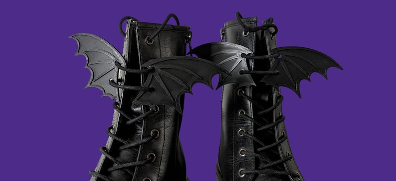 May include: A pair of black leather boots with black bat wing shoe charms attached to the laces.