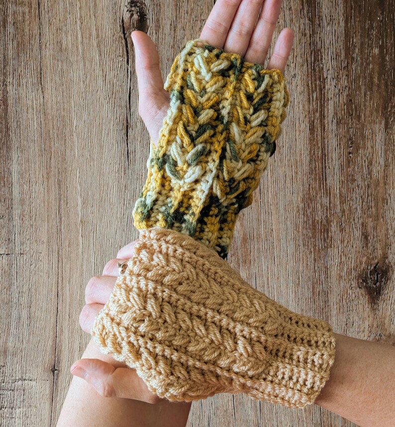 May include: Two handmade crochet fingerless gloves. One glove is a mix of yellow, green, and cream colors. The other glove is a solid tan color. Both gloves have a textured, braided design.