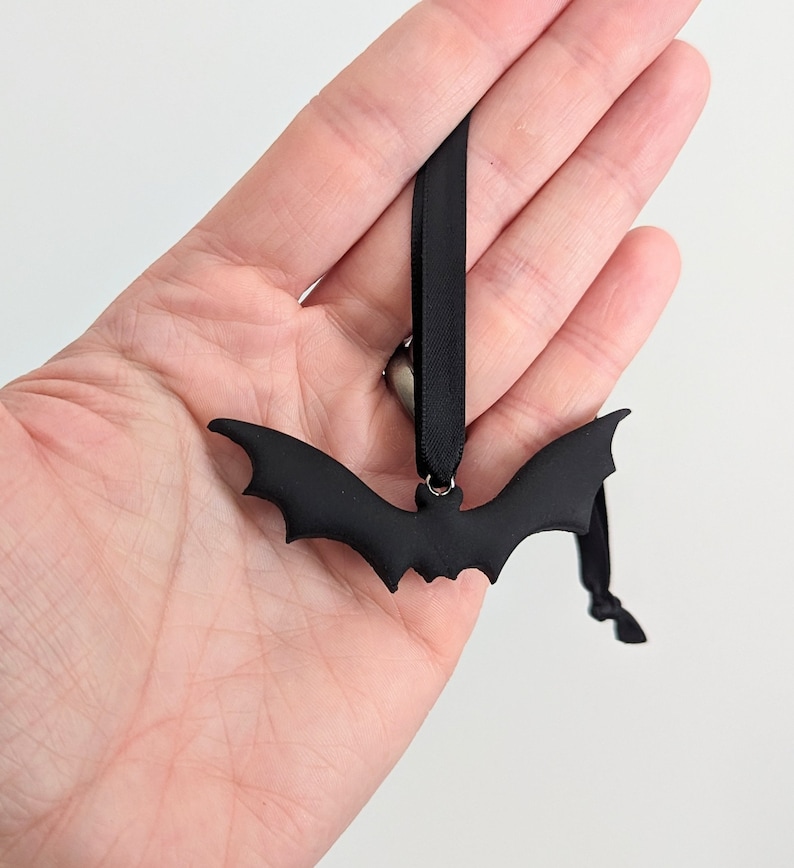 May include: Black bat-shaped ornament with a black ribbon for hanging.