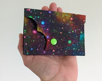 Monedero, billetera, tarjetas de visita, monedas y dinero con diseño de murciélago y galaxia.
