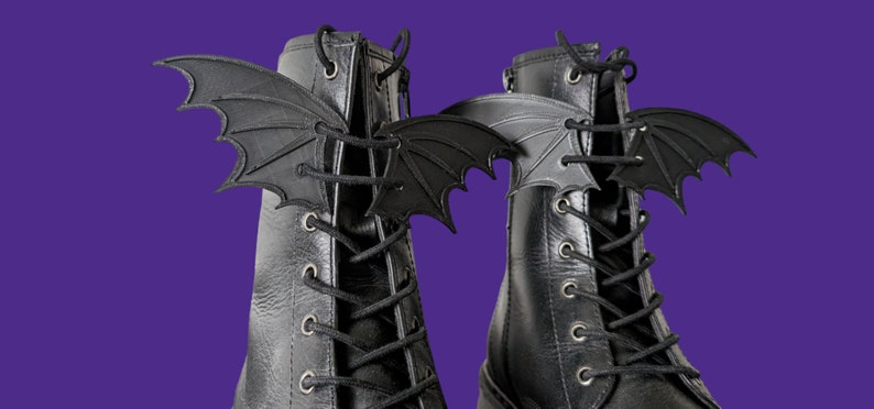 May include: A pair of black leather boots with black bat-shaped lace charms attached to the laces.
