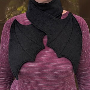 Op de afbeelding: Een zwart vilt vleermuisvleugel kostuum accessoire. De vleugels zijn bevestigd aan een zwarte vilt neksjaal.