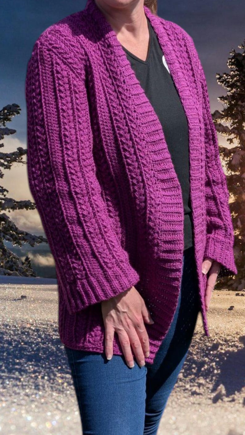 May include: A vibrant purple, open-front cardigan with a cable knit design. The long-sleeved sweater features a ribbed texture and a relaxed fit. The cardigan is made of a soft, warm material, perfect for layering during cooler weather.