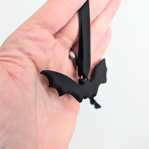 May include: Black bat-shaped ornament with a black ribbon for hanging.