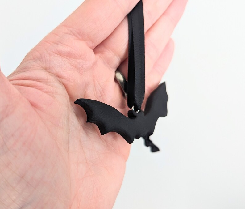 May include: Black bat-shaped ornament with a black ribbon for hanging.