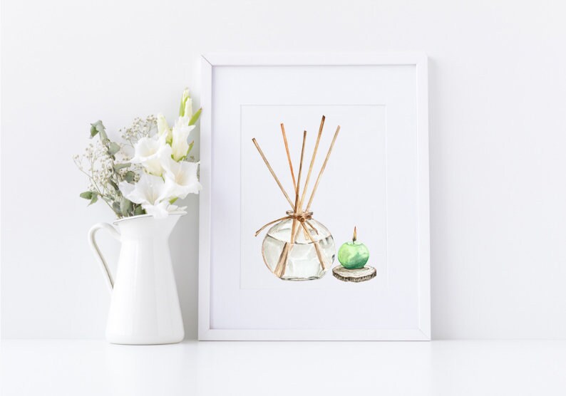 May include: Watercolor painting of a clear glass diffuser with wooden reeds and a green apple candle on a wooden base. The artwork is framed in a white frame and set against a white background. A white pitcher with white flowers is to the left.