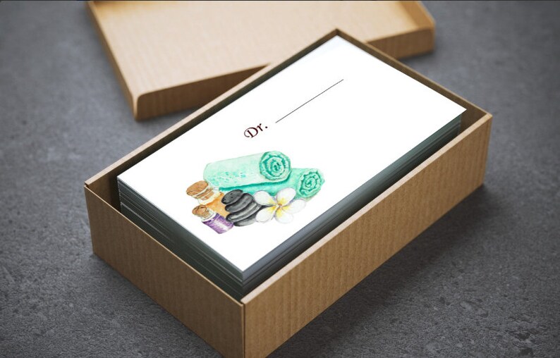 May include: A stack of white cards inside a brown box. The cards feature a watercolor illustration of spa elements, including rolled green towels, black stones, and essential oil bottles. The word "Dr." is printed at the top.