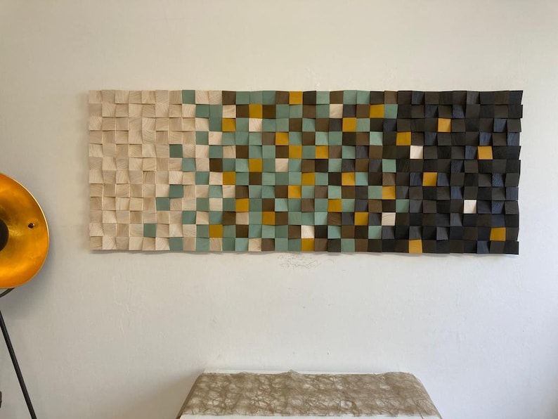 Pu&ograve; includere: Un'opera d'arte da parete realizzata con quadrati di legno in varie tonalit&agrave; di marrone, beige, verde e giallo. I quadrati sono disposti in uno schema geometrico, creando un design moderno e astratto.