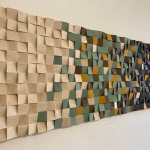 Pu&ograve; includere: Un'opera d'arte da parete in legno con un motivo geometrico. Il pezzo &egrave; composto da quadrati e triangoli in tonalit&agrave; di marrone, verde e beige.