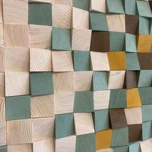 Pu&ograve; includere: Un'opera d'arte murale realizzata con blocchi di legno in varie tonalit&agrave; di marrone, verde e giallo. I blocchi sono disposti a scacchiera, creando un effetto tridimensionale.