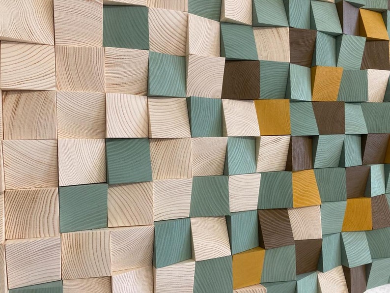 Pu&ograve; includere: Un'opera d'arte murale realizzata con blocchi di legno in varie tonalit&agrave; di marrone, verde e giallo. I blocchi sono disposti a scacchiera, creando un effetto tridimensionale.