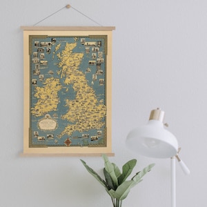May include: A vintage map of Great Britain and Ireland with a blue background and yellow landmasses. The map is framed with a wooden frame and hanging on a white wall. The map is titled "British Isles" and includes a key with symbols for different cities and towns.