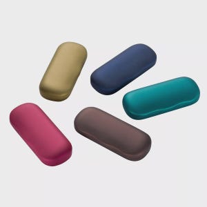 Puede incluir: Cinco estuches ovalados para gafas en tonos dorado, azul marino, turquesa, burdeos y marrón. Las fundas están hechas de un material liso y mate. Los estuches están dispuestos sobre un fondo blanco liso. Los estuches son de varios colores.