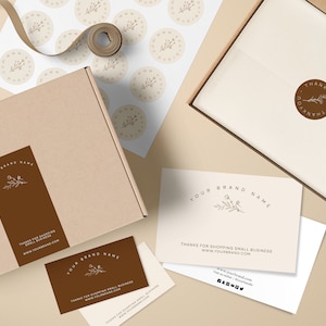 Pu&ograve; includere: Un pacchetto di branding con una combinazione di colori marrone e beige. Include una scatola, adesivi, biglietti da visita e un biglietto di ringraziamento. Il testo include "YOUR BRAND NAME" e "THANKS FOR SHOPPING SMALL BUSINESS".