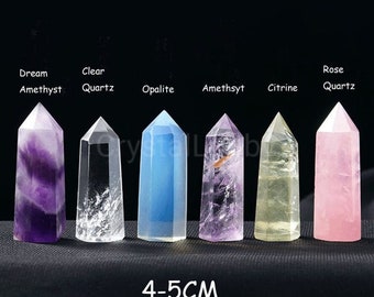 May include: A collection of six crystal towers in various colors, including purple, clear, blue, and pink. Each crystal is labeled with its type, such as Dream Amethyst, Clear Quartz, and Rose Quartz. The crystals are approximately 4-5cm tall.
