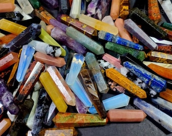 May include: A collection of colorful gemstone wands in various colors, including blue, purple, yellow, and brown. The wands are hexagonal in shape and vary in size. The image is a close-up shot, showcasing the different textures and patterns of the stones.