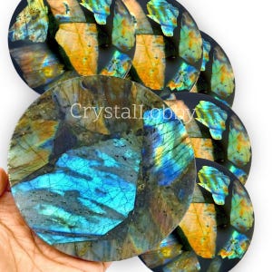 May include: A set of seven iridescent labradorite coasters with a blue, green, and gold color scheme. The coasters are round and have a smooth, polished surface.