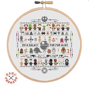 May include: A white embroidery hoop with a cross-stitch design featuring characters from the Star Wars franchise. The design includes a variety of characters, including Luke Skywalker, Darth Vader, Yoda, and Princess Leia. The text "In a galaxy far, far away" is also included in the design.
