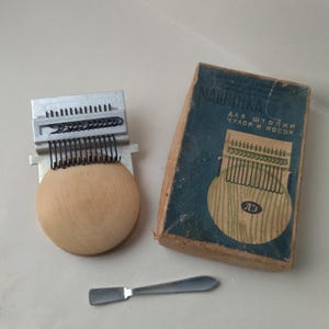 以下が含まれることがあります： 木製のベースと金属部品を備えた、ヴィンテージの靴下繕い機。小さな金属製のツールと、キリル文字と弦楽器のグラフィックが描かれた箱が付属しています。 靴下の修理に使用する機械です。
