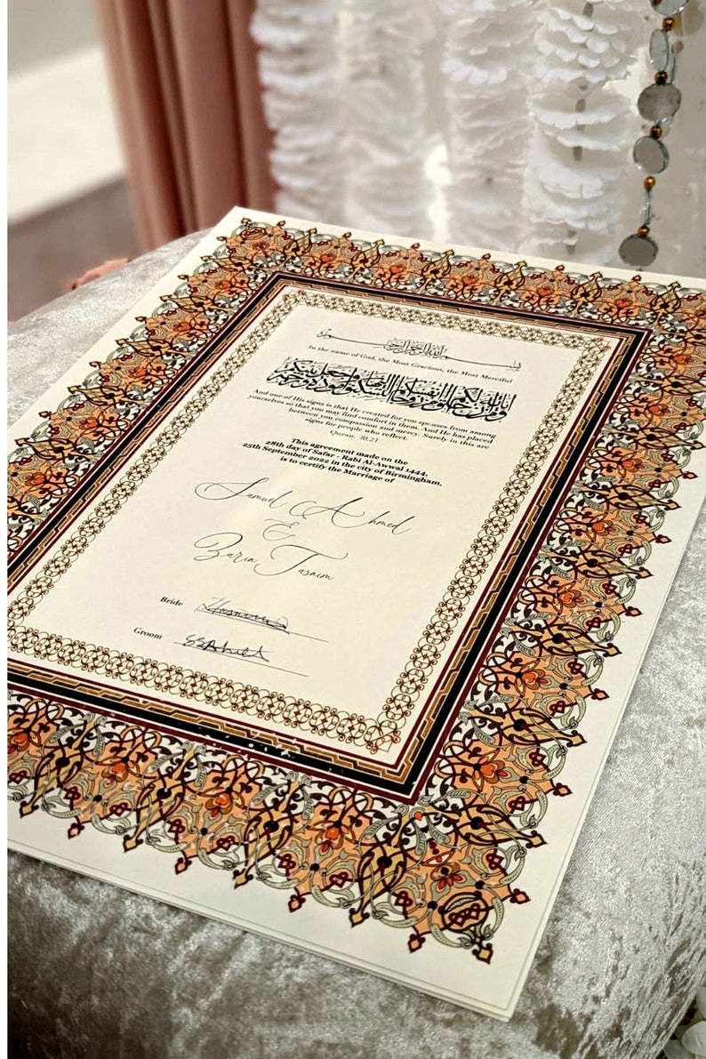 May include: A white document with an ornate border in shades of gold, red, and black. The document is a marriage certificate, with the text "This agreement made on the 28th day of Safar - Rahi Al-Awwal 1444, 25th September 2023 in the city of Birmingham, is to certify the Marriage of Sad & Bari Jasmin." The document is signed by the bride and groom.