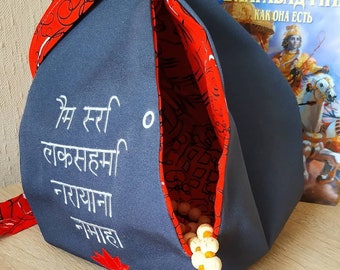 May include: A gray fabric pouch with a red lining and white embroidery that reads "Om Sri Lakshmi Narayana Namaha". The pouch is open and a string of wooden beads is visible inside.