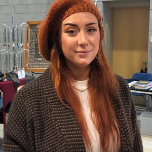 Rust colored tam hat on red haired woman.