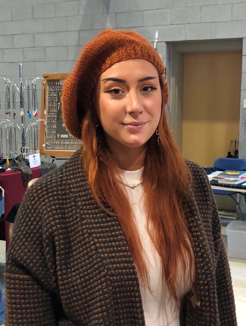 Rust colored tam hat on red haired woman.