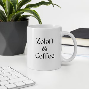 May include: White ceramic coffee mug with black text that reads "Zoloft & Coffee".