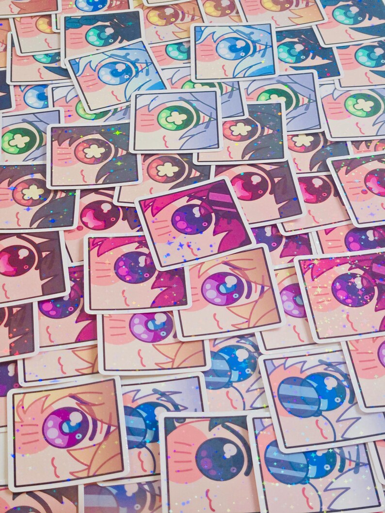Pode incluir: Uma cole&ccedil;&atilde;o de autocolantes quadrados com olhos estilizados em estilo anime em v&aacute;rias cores. Os autocolantes t&ecirc;m um acabamento hologr&aacute;fico. Os desenhos dos olhos incluem azul, verde, roxo e rosa. Os autocolantes est&atilde;o espalhados.