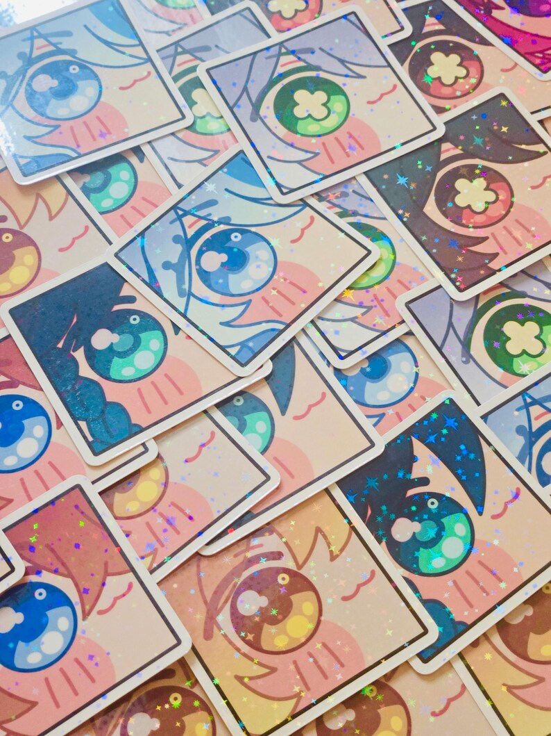 Pode incluir: Uma cole&ccedil;&atilde;o de autocolantes quadrados com desenhos de olhos estilo anime. Os olhos t&ecirc;m v&aacute;rias cores, incluindo azul, verde e castanho, com detalhes brilhantes. Os autocolantes t&ecirc;m um fundo rosa claro e uma borda branca.