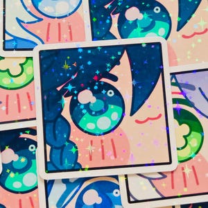 Pode incluir: Autocolantes quadrados com um design de olho estilo anime. O olho &eacute; azul e verde-azulado, com um contorno e cabelo azul escuro. O fundo &eacute; rosa claro com detalhes de estrelas hologr&aacute;ficas. Os autocolantes t&ecirc;m uma borda branca.