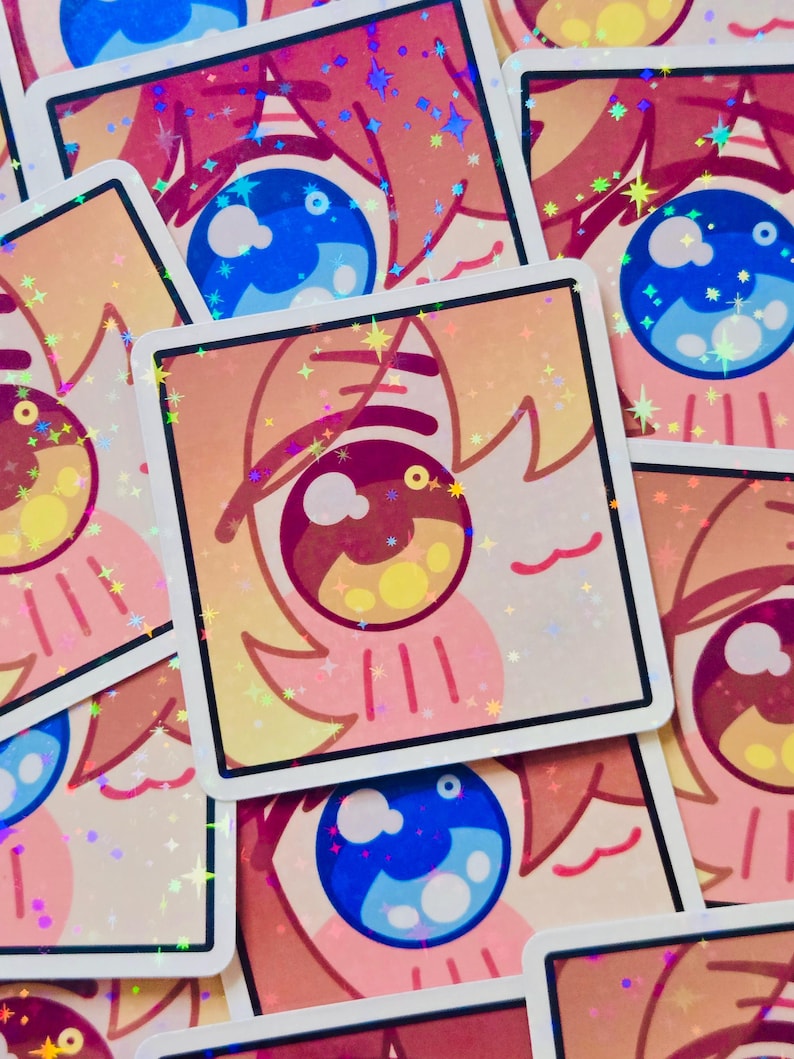 Pode incluir: Autocolantes quadrados com um design de olho de desenho animado em tons de azul, rosa e amarelo. Os autocolantes t&ecirc;m um acabamento hologr&aacute;fico e brilhante, espalhados por uma superf&iacute;cie.