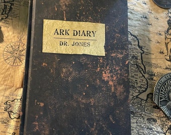 May include: A dark brown leather-bound journal with a gold label that reads "ARK DIARY DR. JONES".