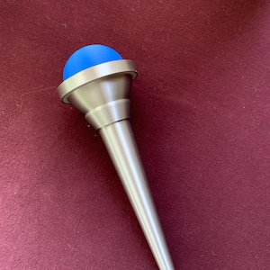 May include: A silver metal trumpet mute with a blue rubber ball on top.