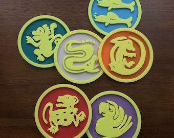 May include: Six round coasters with different colorful designs. Each coaster features a different animal or creature, including a snake, a monkey, a bird, and a lizard. The coasters are made of a durable material and are perfect for protecting your furniture from spills and scratches.