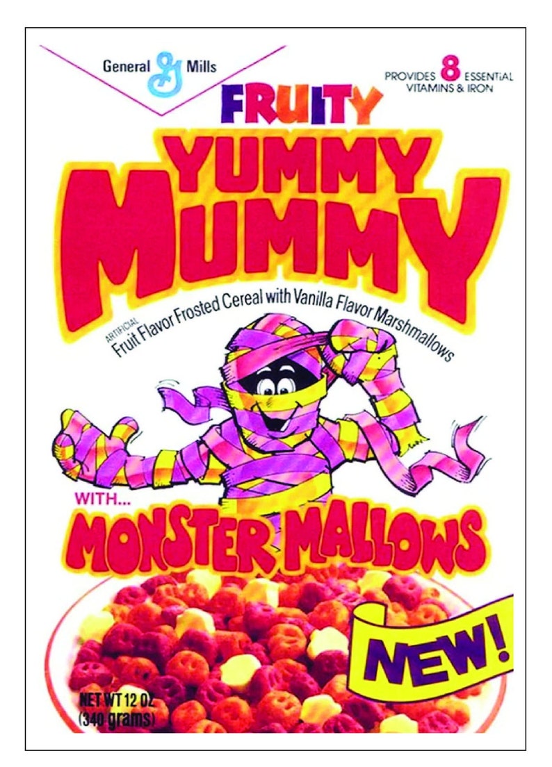 May include: A box of Fruity Yummy Mummy cereal with a cartoon mummy holding a bowl of the cereal. The cereal is a mix of red, yellow, and orange fruit-flavored shapes with vanilla marshmallows. The box says "New!" and "With Monster Mallows".