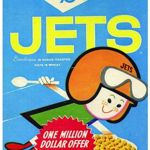 Puede incluir: Una caja de cereal vintage para el cereal General Mills Jets. La caja presenta un personaje de dibujos animados con casco y gafas, volando por el aire con una cuchara. La caja es azul con letras amarillas y una estrella roja y blanca. El texto en la caja dice "Goodness in sugar-toasted oats 'n wheat" y "One million dollar offer $100,000 Grand Prize".