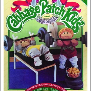May include: A box of Cabbage Patch Kids cereal with a low sugar content. The box features two Cabbage Patch Kids dolls lifting weights. The text on the box reads "Cabbage Patch Kids" and "Low Sugar". The cereal is 10 ounces (283 grams).